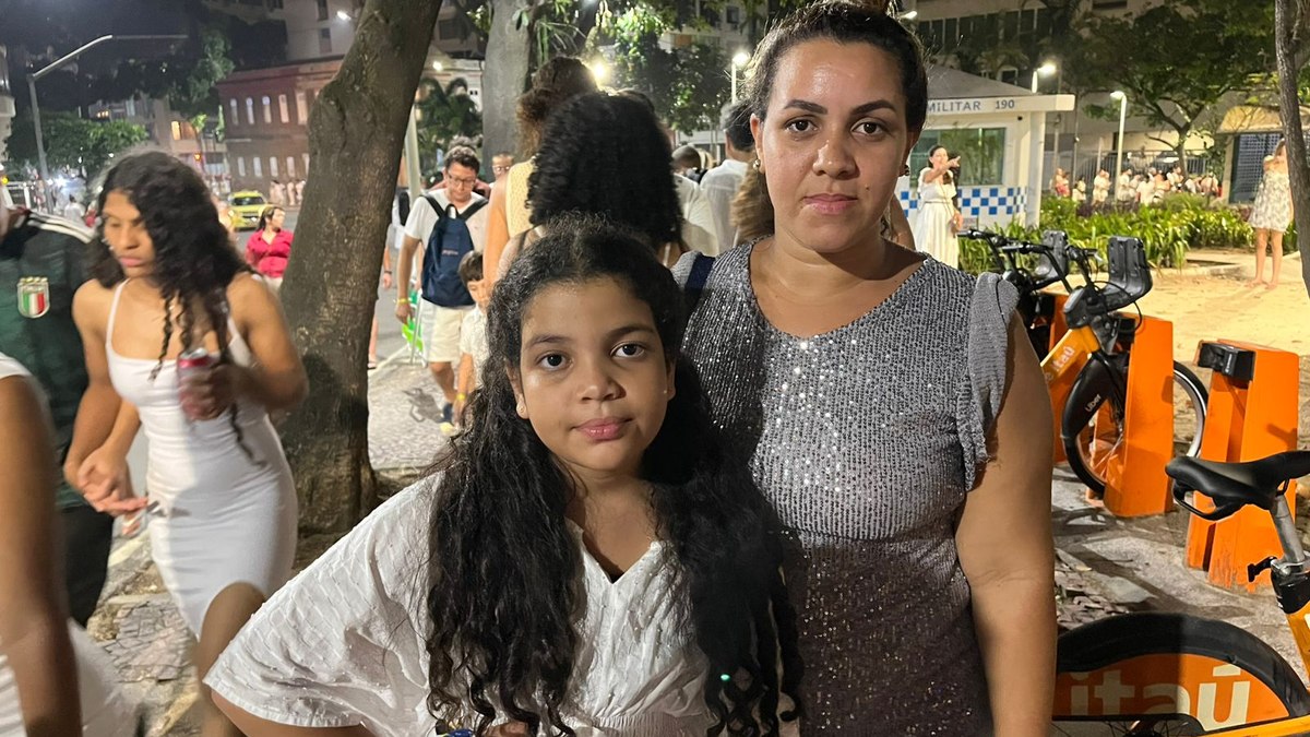 Mãe e filha, Jéssica Pereira, de 38 anos, e Maria, de 8, aguardam na longa fila do metrô do Cantagalo após a queima de fogos em Copacabana. E primeiro Réveillon no Rio marcado por emoção, calor e paciência na volta para casa