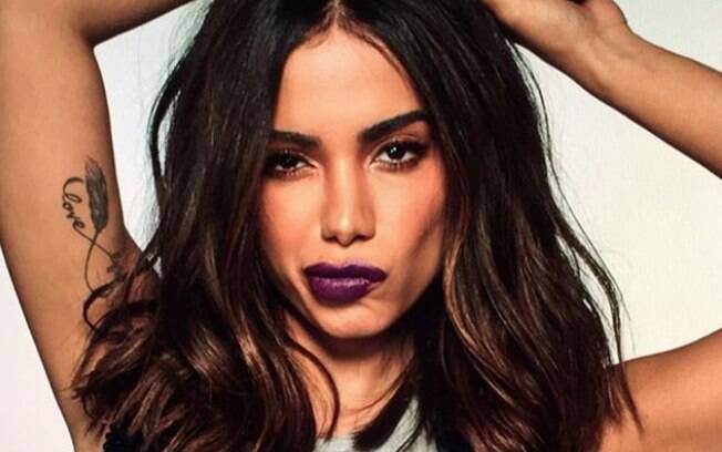 Anitta retorna de viagem, posa de biquíni e mostra marquinha de sol