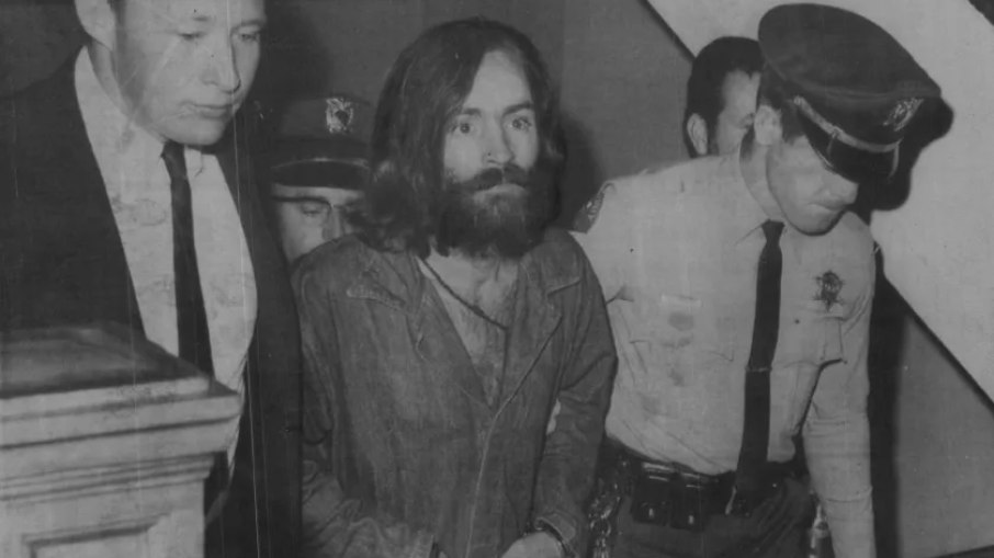 Charles Manson, o responsável pelos assassinatos de Sharon Tate, enquanto era escoltado ao tribunal em 3 de dezembro de 1969, na Califórnia.
