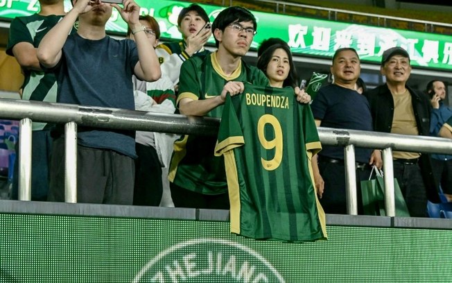 Torcedor segura camisa com o nome e o número do atacante do Gabão Aaron Boupendza durante partida da Super Liga Chinesa entre o Zhejiang FC e o Meizhou Hakka em Hangzhou, na província de Zhejiang, leste da China, em 16 de abril de 2025 Torcedor segura camisa com o nome e o número do atacante do Gabão Aaron Boupendza durante partida da Super Liga Chinesa entre o Zhejiang FC e o Meizhou Hakka em Hangzhou, na província de Zhejiang, leste da China, em 16 de abril de 2025