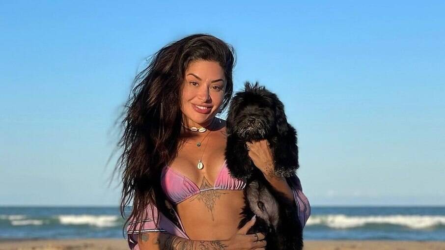 Aline Riscado compartilha foto ao lado de cãozinho na praia