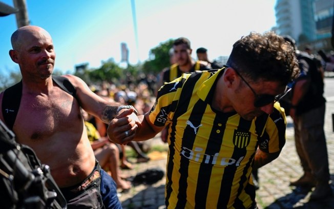 Torcedores uruguaios do Peñarol são detidos na praia do Recreio dos Bandeirantes, no Rio de Janeiro, nesta quarta-feira, antes do jogo de ida da semifinal da Copa Libertadores contra o Botafogo.