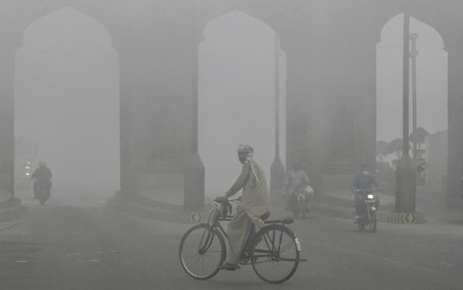 Ciclista pedala em Lahore, no Paquistão, em meio a uma densa poluição atmosférica