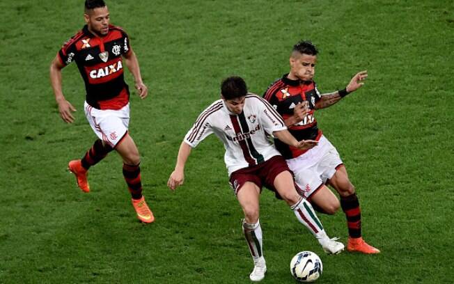 O meia argentino Conca, do Fluminense, disputa a bola com João Paulo e Éverton, do Flamengo, no clássico de domingo. Foto: Getty Images/Buda Mendes