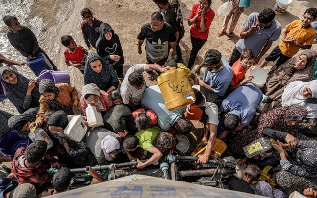 Palestinos aguardam distribuição de água diante de caminhão-tanque em Deir el-Balah, no centro da Faixa de Gaza, em 30 de abril de 2024