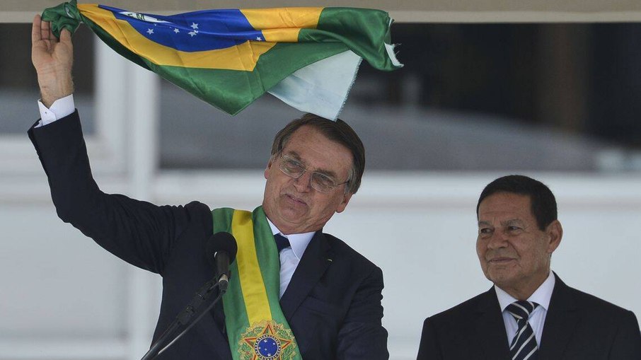 Jair Bolsonaro agita bandeira durante seu discurso como presidente