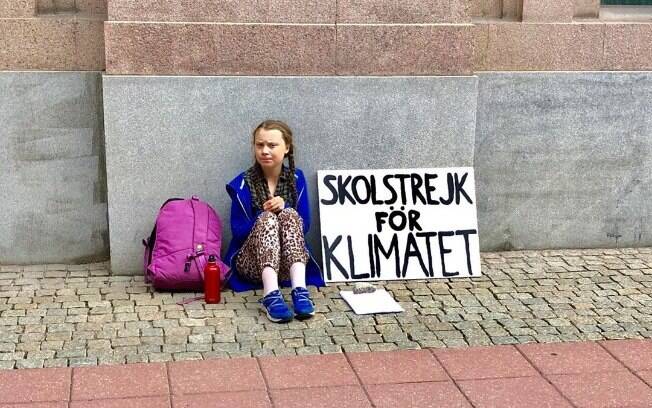 Greta se senta em frente ao parlamento, sempre com a mesma placa