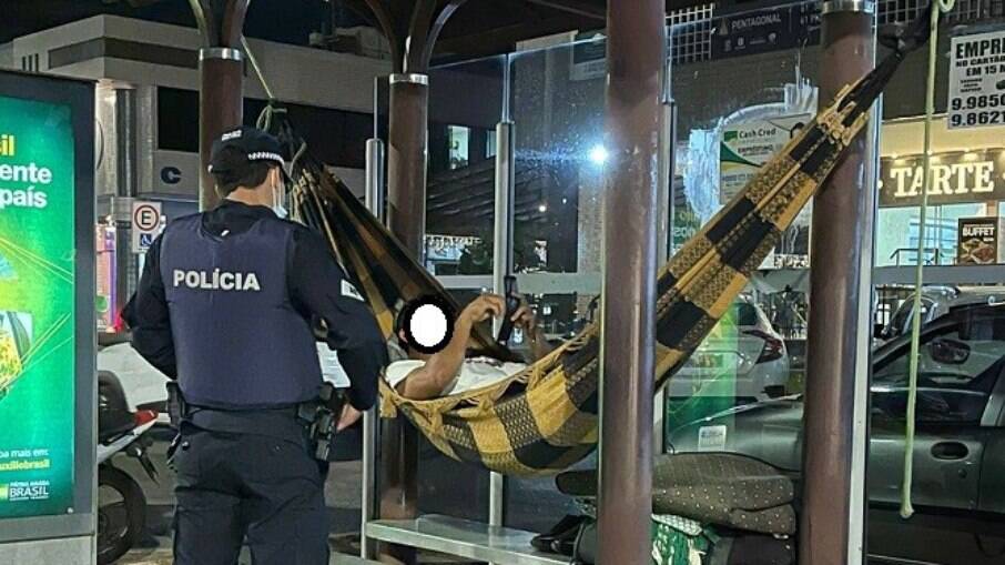 Homem foragido é encontrado deitado numa rede pendurada em um ponto de ônibus