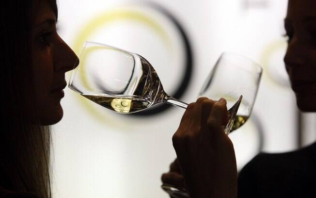 Mulher bebe vinho branco durante exposição de vinhos em Verona, na Itália