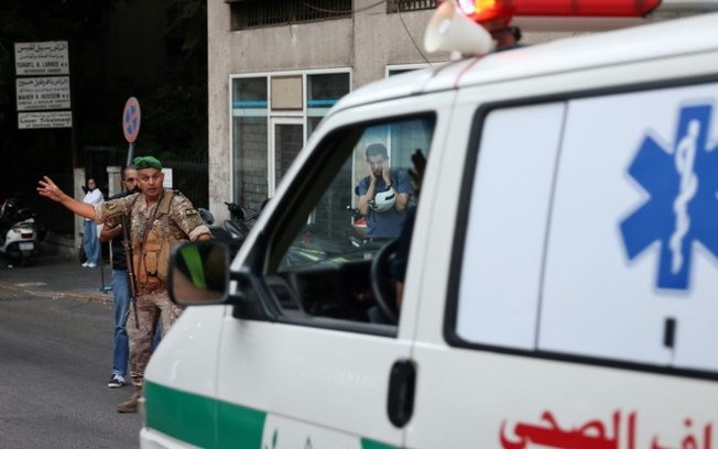 Um soldado do Exército libanês gesticula para uma ambulância que levava pessoas feridas para um hospital em Beirute, em 17 de setembro de 2024, depois que explosões atingiram vários redutos do Hezbollah ao redor do Líbano