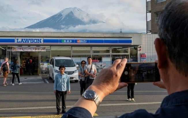 Turistas tiram foto do Monte Fuji na cidade de Fujikawaguchiko