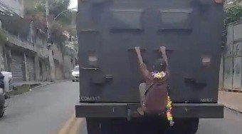 Homem se pendura em traseira de veículo blindado da PM no Rio