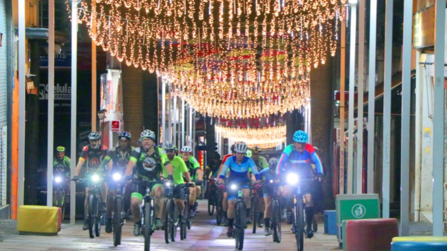 Ciclistas pedalando, à noite, na rua 13 de maio.