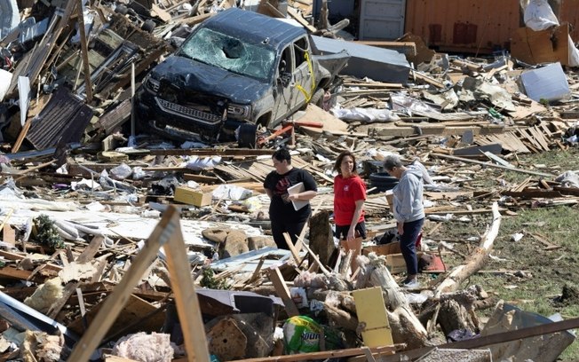 Moradores de Greenfield, Iowa, Estados Unidos, caminham pela cidade depois que ela foi destruída por um tornado em 23 de maio de 2024