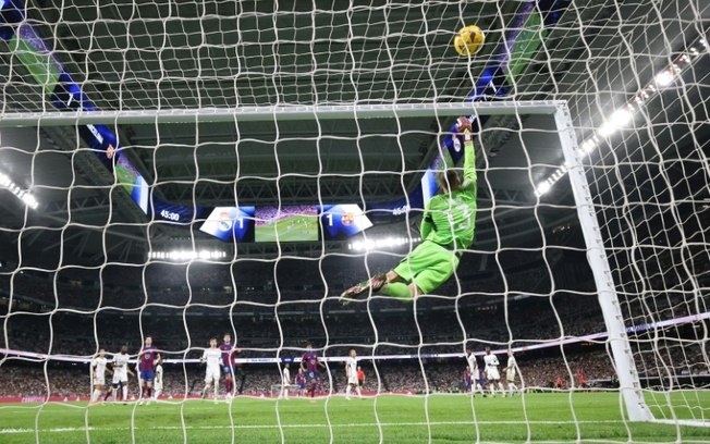 O goleiro ucraniano do Real Madrid, Andriy Lunin, defende um chute durante a partida contra o Barcelona pelo Campeonato Espanhol, no Estádio Santiago Bernabéu, em Madri, em 21 de abril de 2024