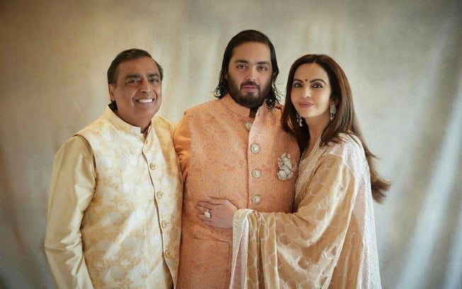 O magnata bilionário indiano Mukesh Ambani (à esquerda), a sua mulher Nita (à direita) e o filho Anant, em 2 de março de 2024