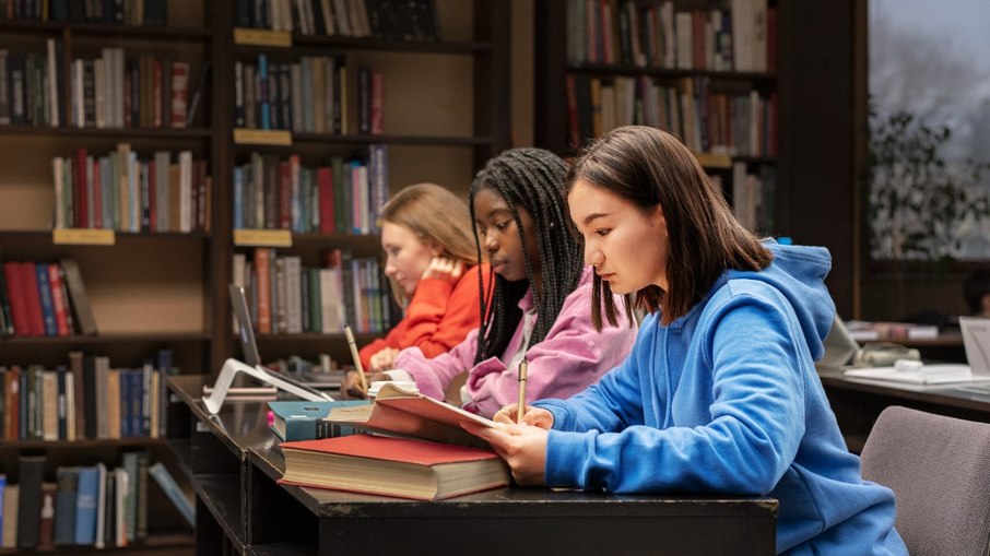 Mulheres reunidas em uma biblioteca enquanto leem