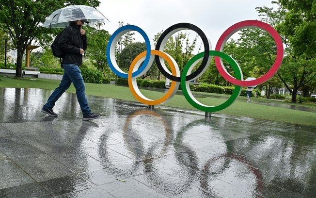 Um visitante caminha na chuva em frente ao Museu Olímpico de Tóquio, em 1º de maio de 2024.