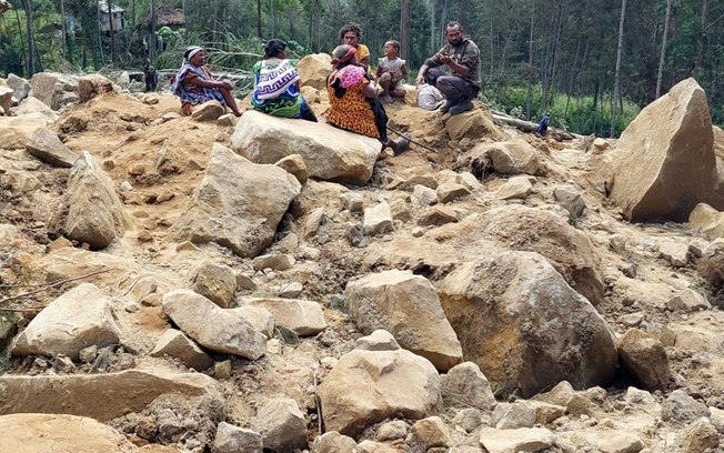 Moradores do vilarejo de Yambali procuram sobreviventes