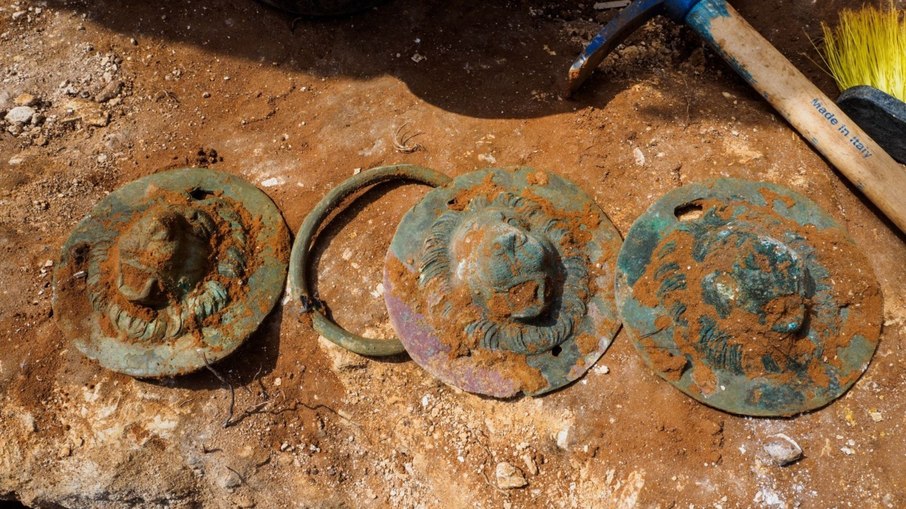 Três discos com cabeças de leão desenterrados Três discos com cabeças de leão desenterrados