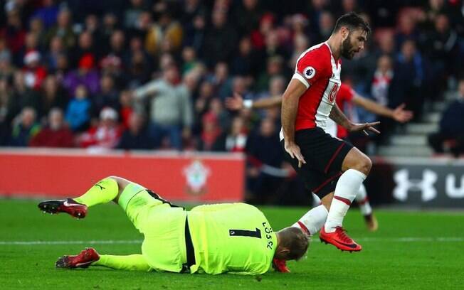 Charlie Austin, jogador do Southampton, dá chute no rosto do goleiro rival, Jonas Lossl