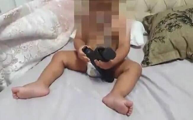 Nas imagens, é possível ver o bebê com a arma e diversas cápsulas de munição dentro do berço