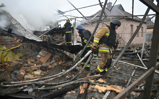 Equipes de emergência trabalham em área atingida por ataque com drone em Kharkiv, noroeste da Ucrânia, nesta quarta-feira (25)