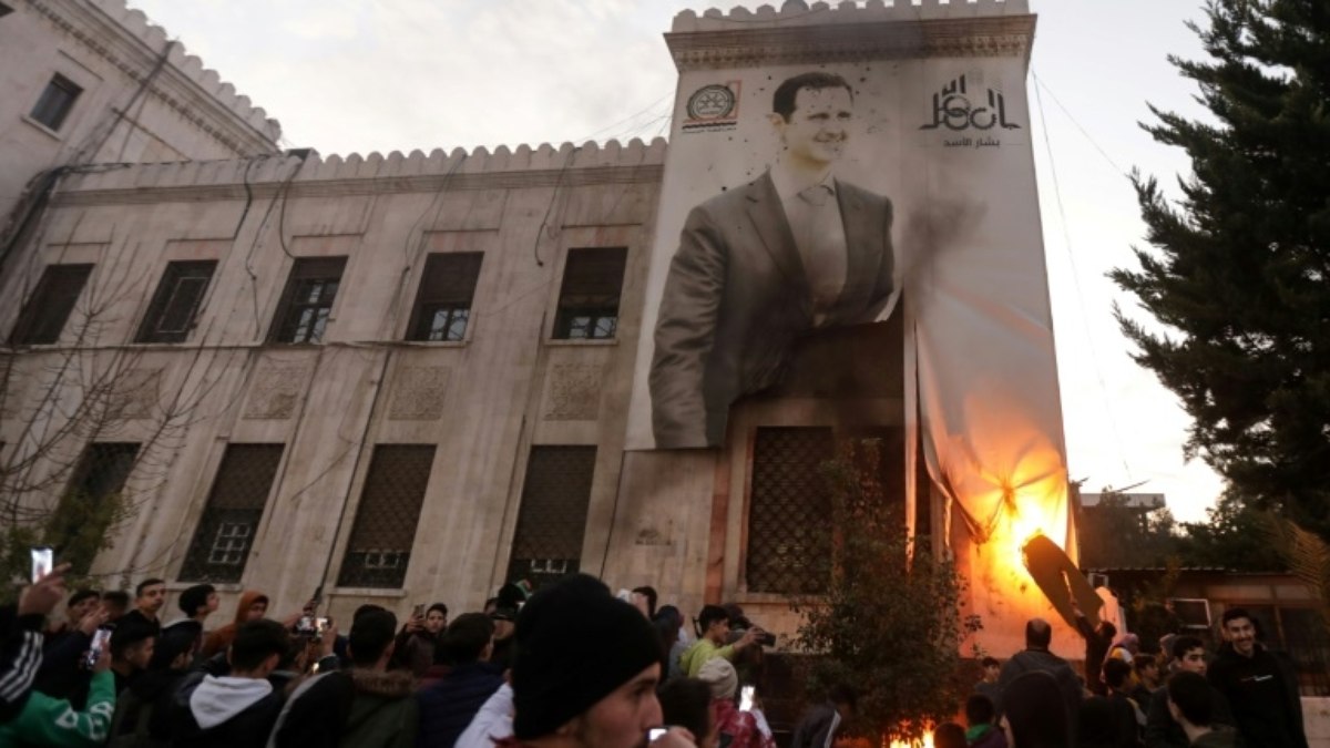 Moradores queimam foto do presidente sírio Bashar al-Assad em Hama, após a tomada da cidade pelos rebeldes, em 5 de dezembro de 2024