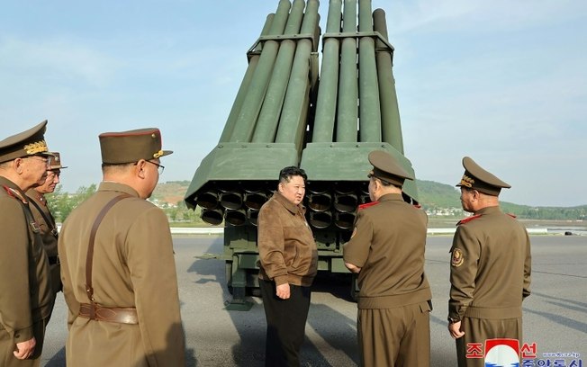 O líder norte-coreano Kim Jong Un inspeciona um sistema múltiplo de lança-foguetes ao lado de oficiais do Exército em 10 de maio de 2024, em imagem divulgada pela agência de imprensa estatal KCNA