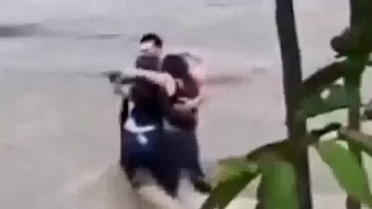 Three friends embrace before the river carries them into Italy