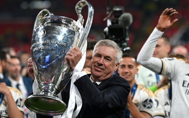 O técnico italiano do Real Madrid, Carlo Ancelotti, ergue o troféu para comemorar a vitória na final da Champions League contra o Borussia Dortmund, no estádio de Wembley, em Londres, no dia 1º de junho de 2024.