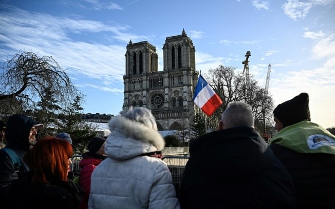 Franceses observam a Catedral de Notre-Dame em Paris atrás de um cordão de segurança, em 6 de dezembro de 2024