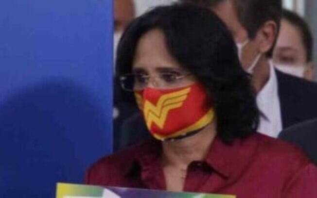 A ministra Damares Alves usa máscara temática de Mulher Maravilha em coletiva