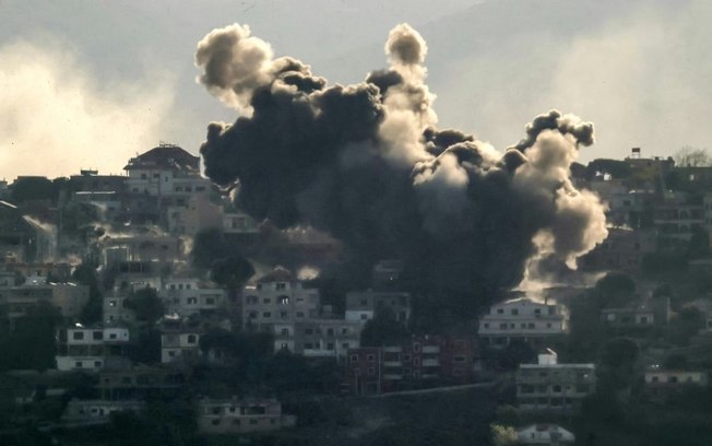 Uma nuvem de fumaça sobe do local de um ataque aéreo israelense que teve como alvo a vila de Khiam, sul do Líbano, 9 de outubro de 2024