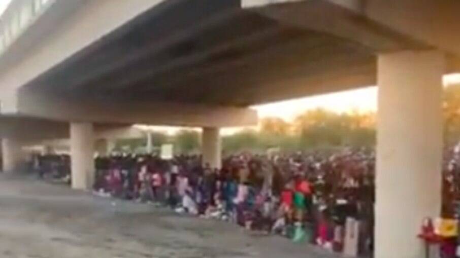 Imigrantes debaixo da Ponte Internacional Del Rio enquanto esperam para se entregar à Patrulha de Fronteira dos EUA e pedir asilo