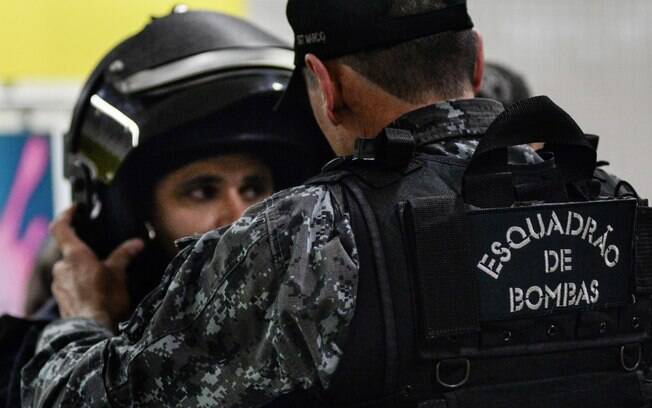 Mesmo em caso de negociação, não é incomum a presença do Esquadrão de Bombas. Aqui, um Policial ajuda seu companheiro a vestir a roupa e equipamentos para se proteger de uma possível detonação