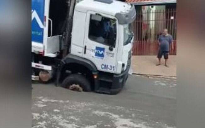 Caminhão de lixo cai em buraco após asfalto ceder em Campinas