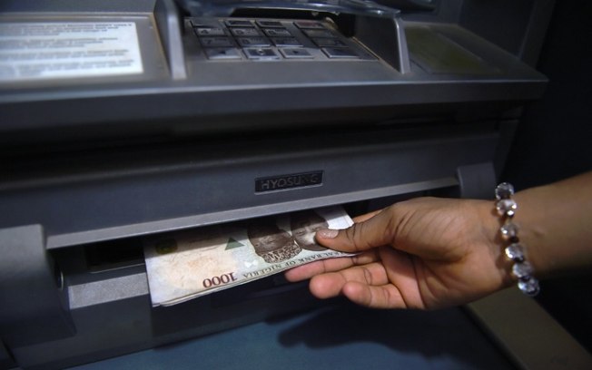 Um cliente retira notas de naira de um caixa eletrônico em Asaba, Nigéria, em 10 de novembro de 2016