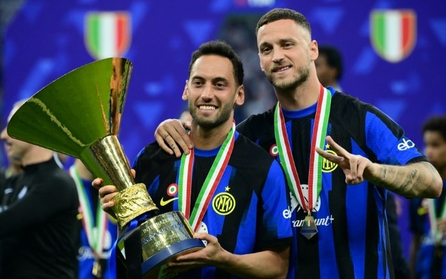 Hakan Calhanoglu segura o troféu da Serie A ao lado de Marko Arnautovic na comemoração do título da Inter de Milão