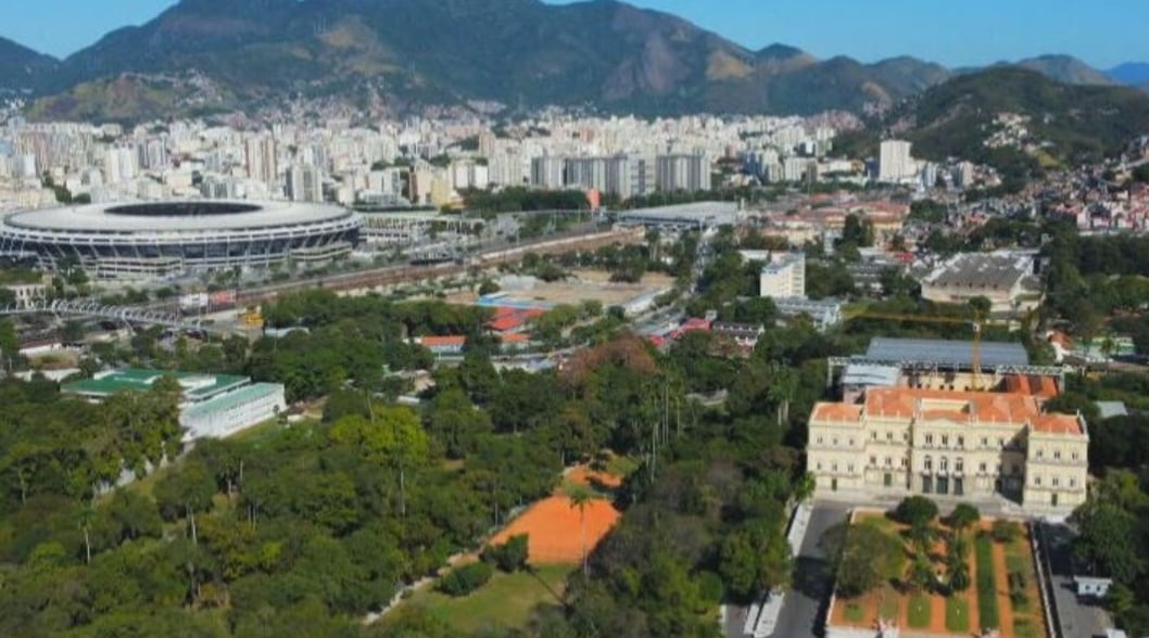 Fundado em 1818, o museu é um dos maiores de História Natural e Antropologia das Américas. Fica na Quinta da Boa Vista, em São Cristóvão, bairro próximo ao Maracanã. Do alto, se vê o museu e o estádio, relativamente próximos. Reprodução: Flipar