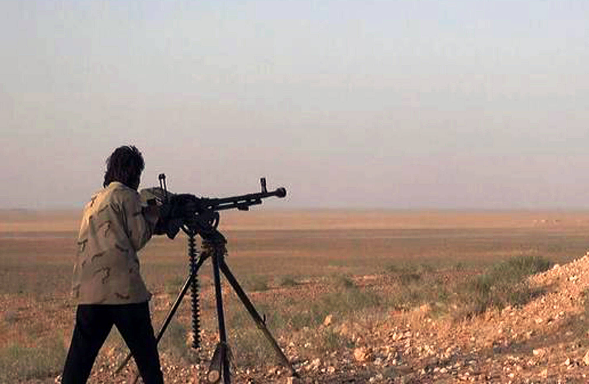 Militante do Estado Islâmico aponta arma durante batalha contra as forças do governo sírio em uma estrada entre Homs e Palmyra (maio/2015). Foto: AP