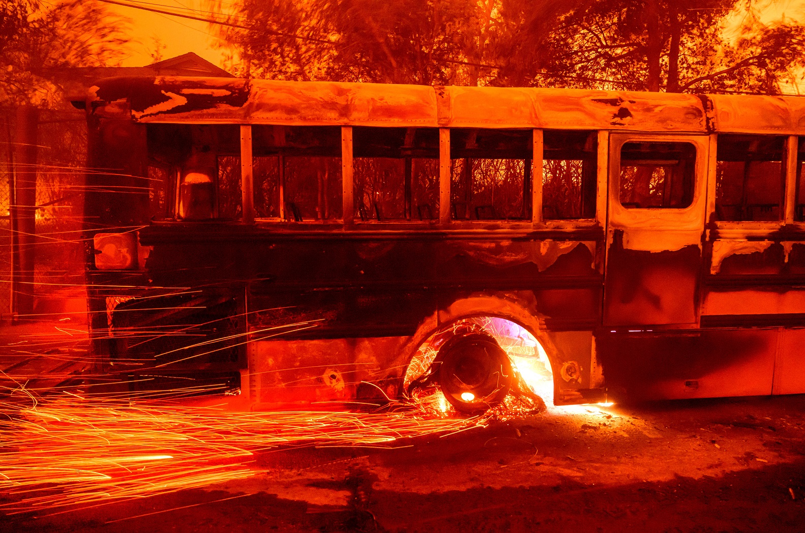 Brasas voam de um ônibus em chamas na escola primária Aveson School of Leaders durante o incêndio de Eaton na área de Altadena, no Condado de Los Angeles, Califórnia, em 8 de janeiro de 2025 Josh Edelson/AFP