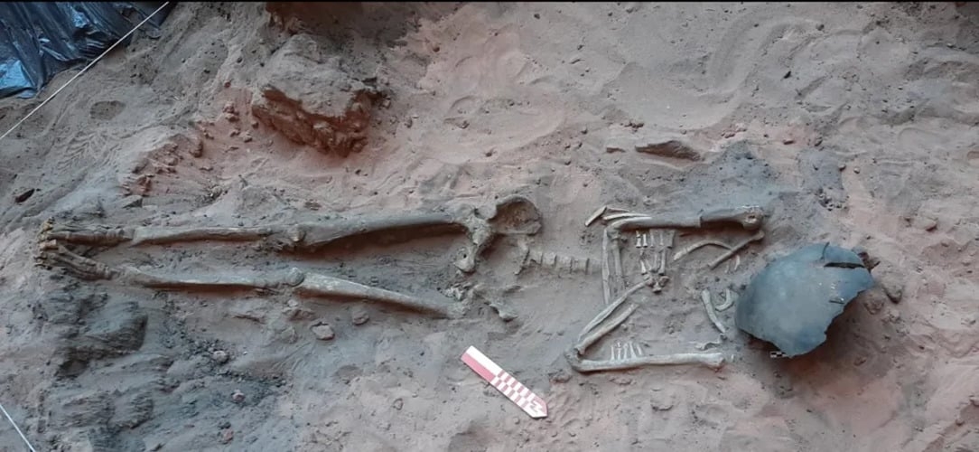 Arqueólogos encontraram um esqueleto de um homem adulto, inteiro, com um fragmento de cerâmica cobrindo o rosto, braceletes e colar feitos de contas em osso.