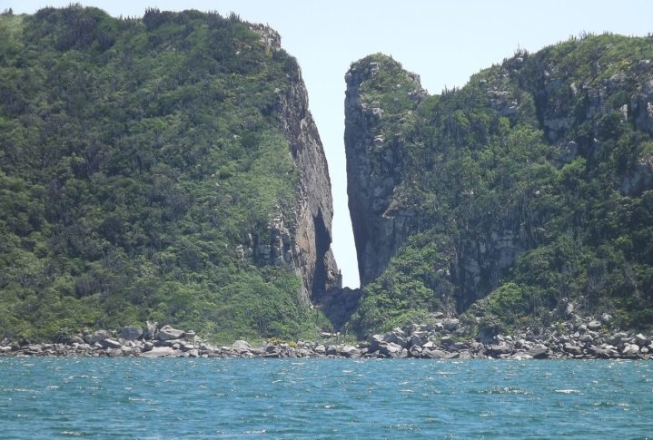 Fenda de Nossa Senhora: É um acidente geográfico localizado na Ilha do Farol, em Arraial do Cabo, no Rio de Janeiro. É uma fenda rochosa, dando a impressão de ter sido retirada uma fatia da ilha, como se cortasse um bolo. Reprodução: Flipar