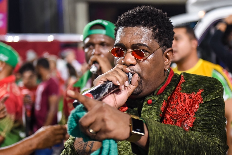 Desde 2019 está à frente do carro de som da Grande Rio, ganhou o Estandarte de Ouro em 2020 e o carnaval em 2022, com o enredo sobre o orixá Exu. Antes disso, teve uma passagem pela Acadêmicos do Cubango, escola de Niterói.
 Reprodução: Flipar