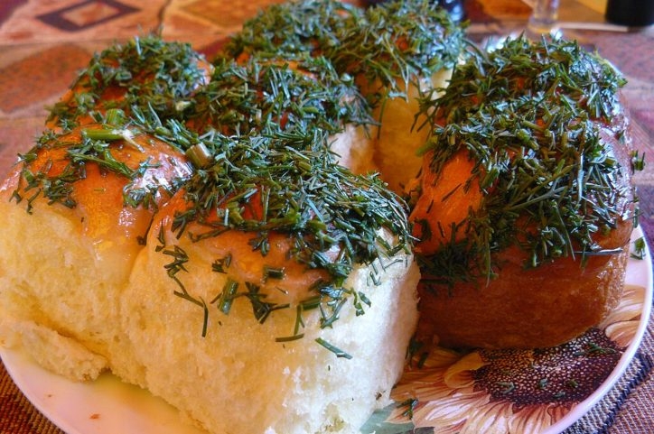 Uma característica distintiva das pampushkas é que elas são muitas vezes cobertas com um molho de alho e ervas. Este molho é feito misturando alho picado, endro fresco (ou outras ervas) e óleo vegetal ou manteiga derretida.  Reprodução: Flipar