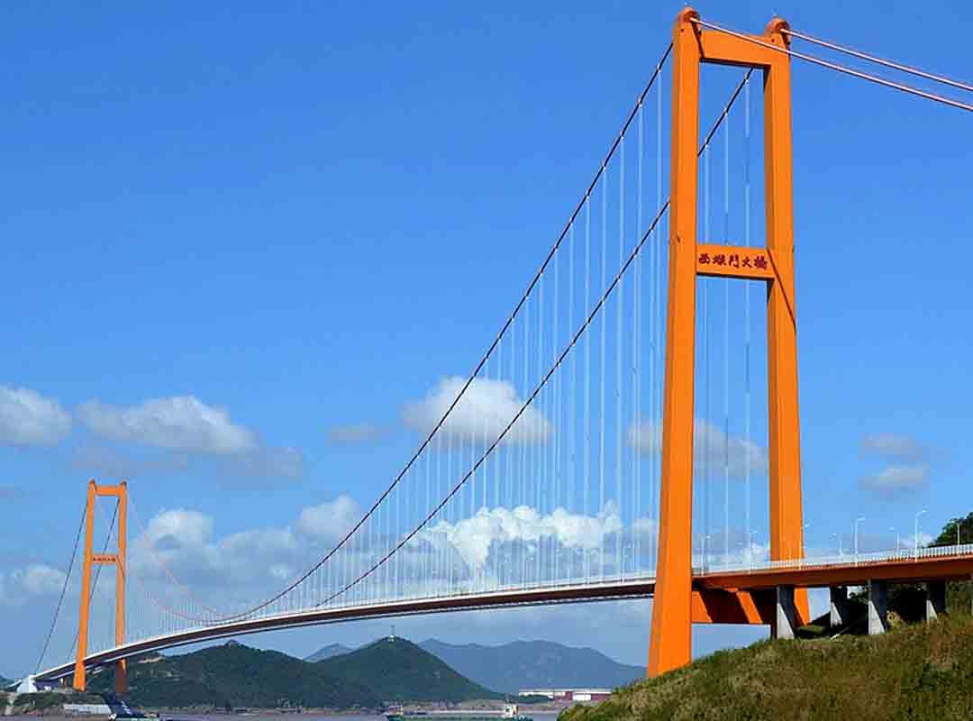 Xihoumen, China: Localizada no Arquipélago de Zhoushan e inaugurada em 2009, é uma ponte suspensa impressionante que se estende por 2.220 metros pelo estuário de Hangzhou. A construção da ponte envolveu tecnologias avançadas para a época, com o uso de cabos de aço de alta resistência e técnicas inovadoras de ancoragem. Reprodução: Flipar