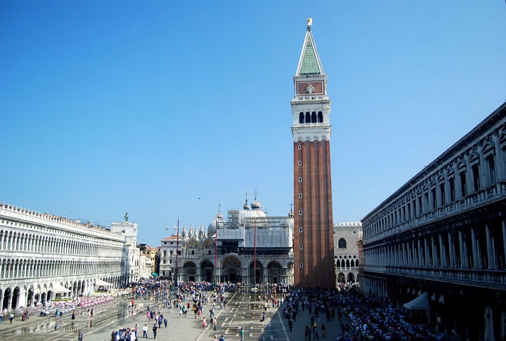 Praça de São Marcos - Veneza - Itália. A praça é famosa por sua arquitetura impressionante e seu vibrante ambiente. Frequentemente, pombos e turistas preenchem o espaço, enquanto músicos e cafés contribuem para a atmosfera animada. A praça também é conhecida por seus eventos culturais e festivais ao longo do ano. Reprodução: Flipar