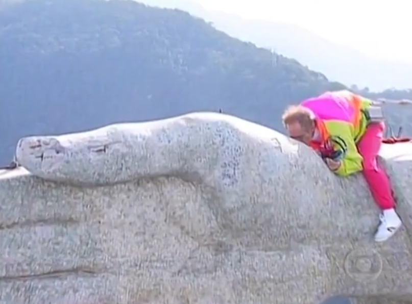 Depois, ele retirou os fones de ouvido e se inclinou para beijar a mão de Cristo. Um dos momentos inesquecíveis da vida do humorista e que também deixou uma marca para muitas pessoas que acompanharam a imagem.  Reprodução: Flipar