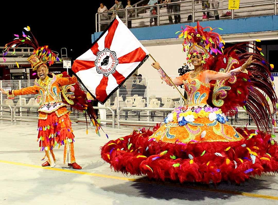 O concurso de escolas de samba começou a despontar e com ele homens e mulheres passaram a ter seus locais definidos. De um lado o mestre-sala deveria cortejar com garbo elegância, enquanto do outro, a porta-bandeira deveria carregar o pavilhão com leveza e muita dança. Reprodução: Flipar
